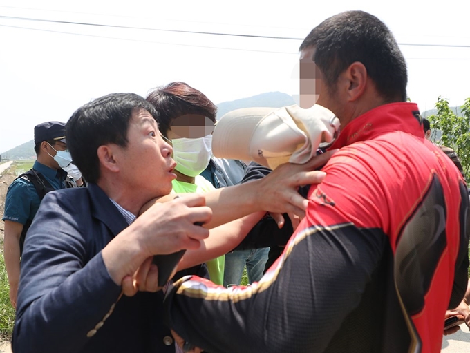 박상학(왼쪽) 자유북한운동연합 대표가 8일 인천 강화군 삼산면 석모리 한 해안가 진입로에서 통행을 막아선 주민에 반발하고 있다. 박 대표와 탈북민단체 회원들은 이날 이 지역 해안가에서 쌀을 담은 페트(PET)병을 바다에 띄워 북측에 보내는 행사를 개최하려다가 주민 반발에 부딪혀 실패하고 되돌아갔다. 인천=연합뉴스