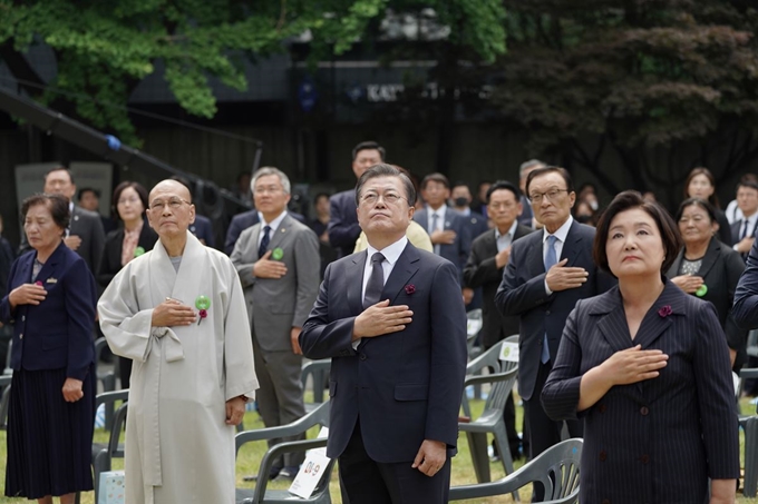 문재인 대통령과 부인 김정숙 여사가 10일 오전 서울 용산구 민주인권기념관에서 열린 6·10 민주항쟁 기념식에서 국기에 경례하고 있다. 연합뉴스