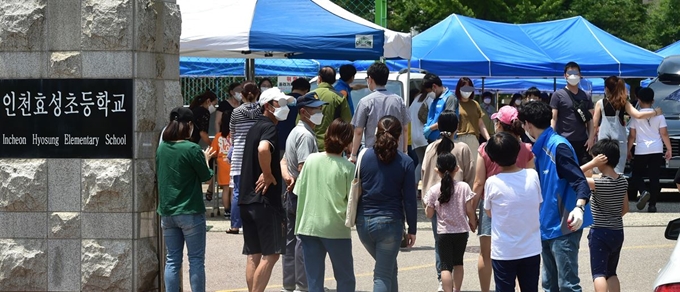 14일 오후 인천 계양구 효성초등학교에서 학생과 교직원들이 검사를 받기 위해 교내 마련된 선별진료소에 들어서고 있다. 뉴스1