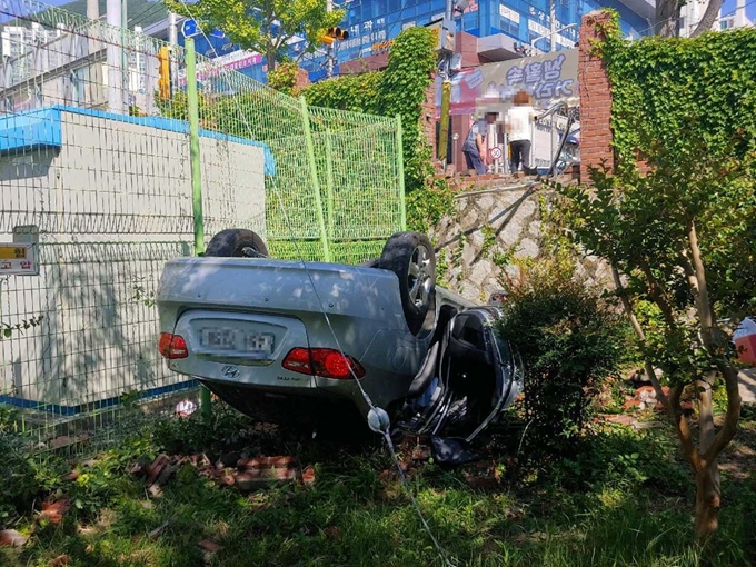 15일 부산 해운대구 한 초등학교 앞 스쿨존 보행로를 건너다 교통사고를 당한 6세 유치원생이 16일 끝내 숨졌다. 사진은 사고 현장에 전복돼 있는 가해 차량. 부산경찰청 제공