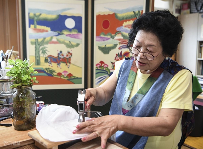 [저작권 한국일보][이런 2막] 김영순 교수가 11일 오전 경기 포천시 작업실에서 민화에 색을 입히는데 사용하는 쪽 색을 추출하고 있다. 이한호 기자