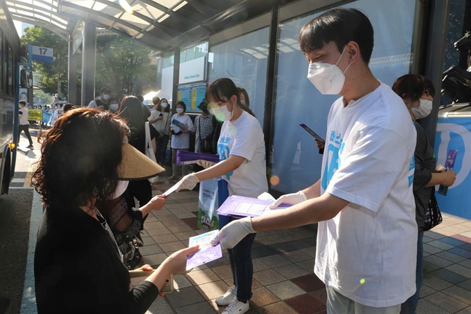 지난 10일 오전 부산 서면역 일대에서 부산시내버스운송사업조합 직원들이 생활 방역을 위한 마스크와 손 소독제를 시민에게 나눠주며 대중교통 이용 캠페인을 하고 있다. 부산=연합뉴스