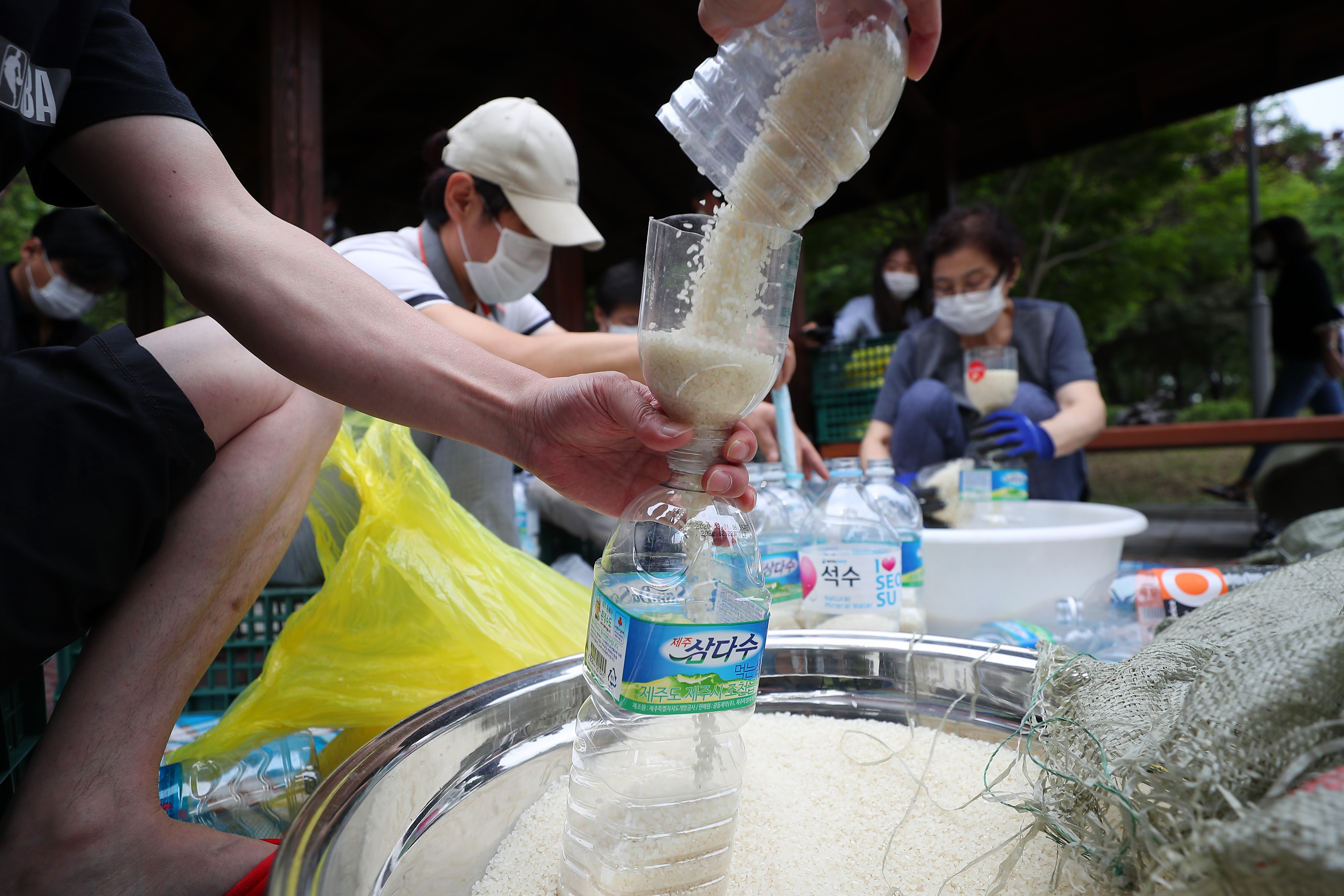 탈북단체 '큰샘' 회원들이 18일 서울 강남구 일원동 일대에서 북한에 보낼 쌀을 페트병에 담고 있다. 이들은 오는 21일 강화 석모도에서 페트병에 쌀과 마스크를 담아 북한에 보낼 예정이다. 뉴시스