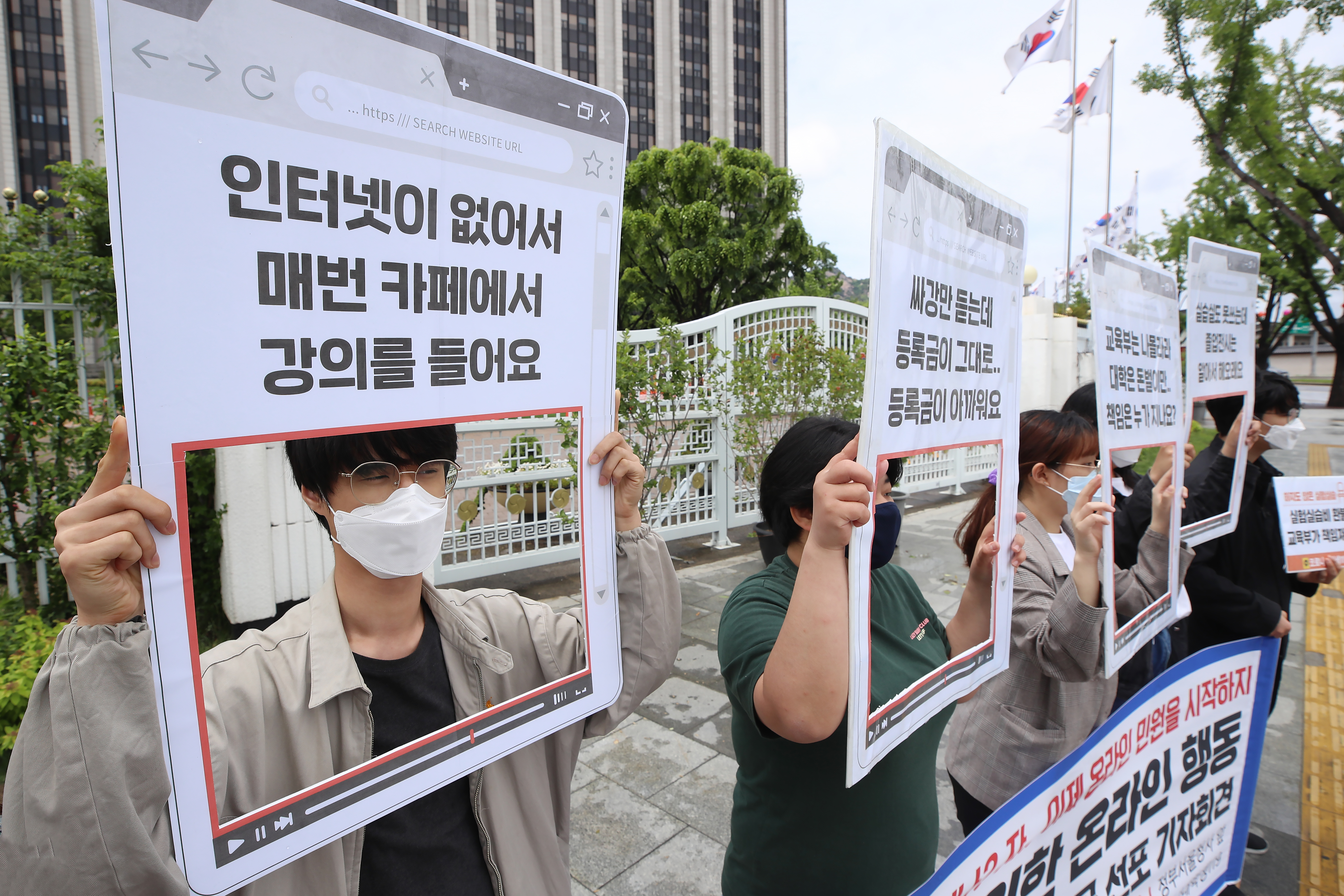 지난달 19일 정부서울청사 앞에서 열린 등록금 환불을 위한 온라인 행동 교육부총공 선포 기자회견에서 코로나대학생119ㆍ청년민중당 관계자들이 손팻말을 들고 있다. 연합뉴스