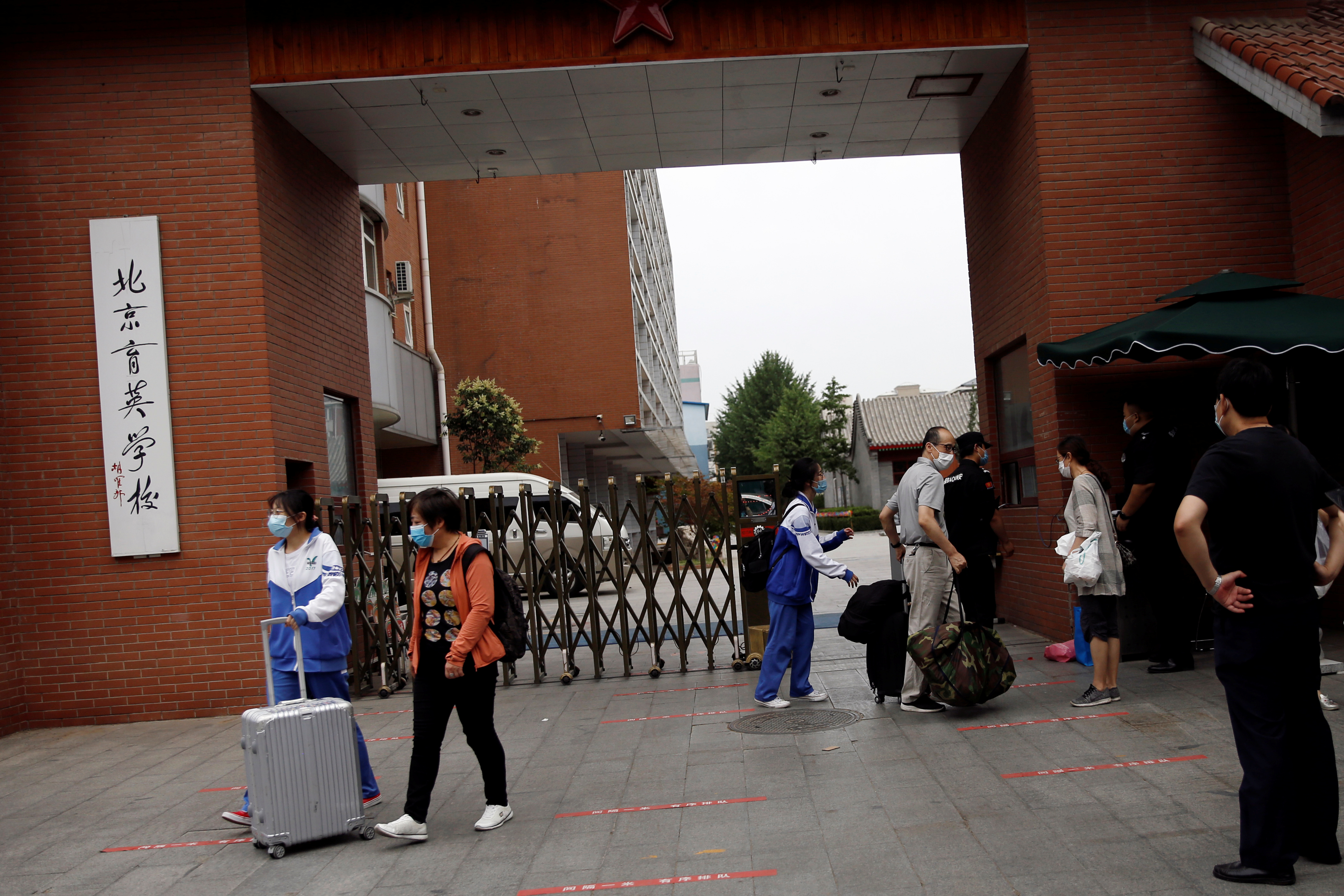 중국 베이징시가 등교를 전면 중단하고 초중고교 전 학년 수업을 온라인으로 전환한 17일 아침 중학생들이 소지품을 챙겨 부모와 함께 집으로 돌아가고 있다. 베이징=로이터 연합뉴스