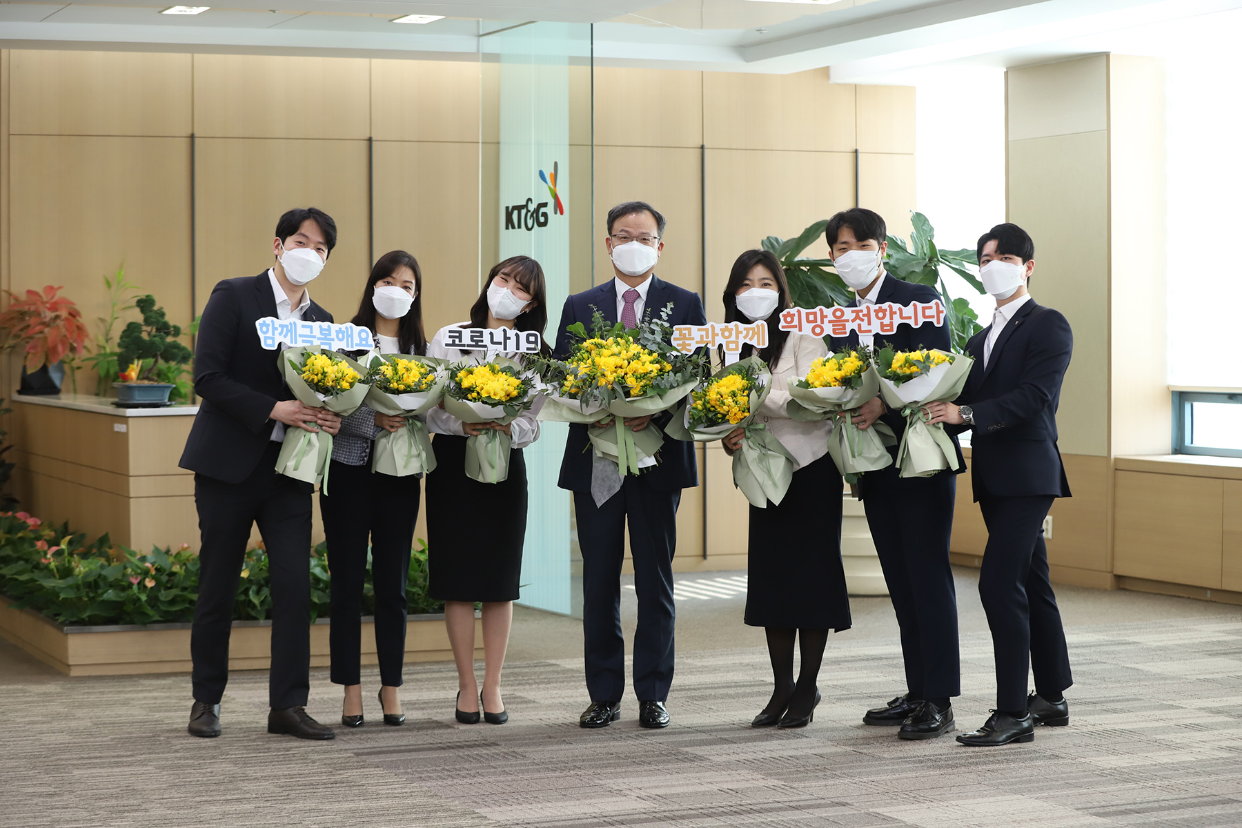 백복인(가운데) KT&G 사장이 창립기념일을 앞둔 3월 화훼농가 돕기 캠페인의 일환으로 직원들에게 꽃을 선물한 뒤 강남구 서울사옥에서 기념 사진을 찍고 있다. KT&G 제공