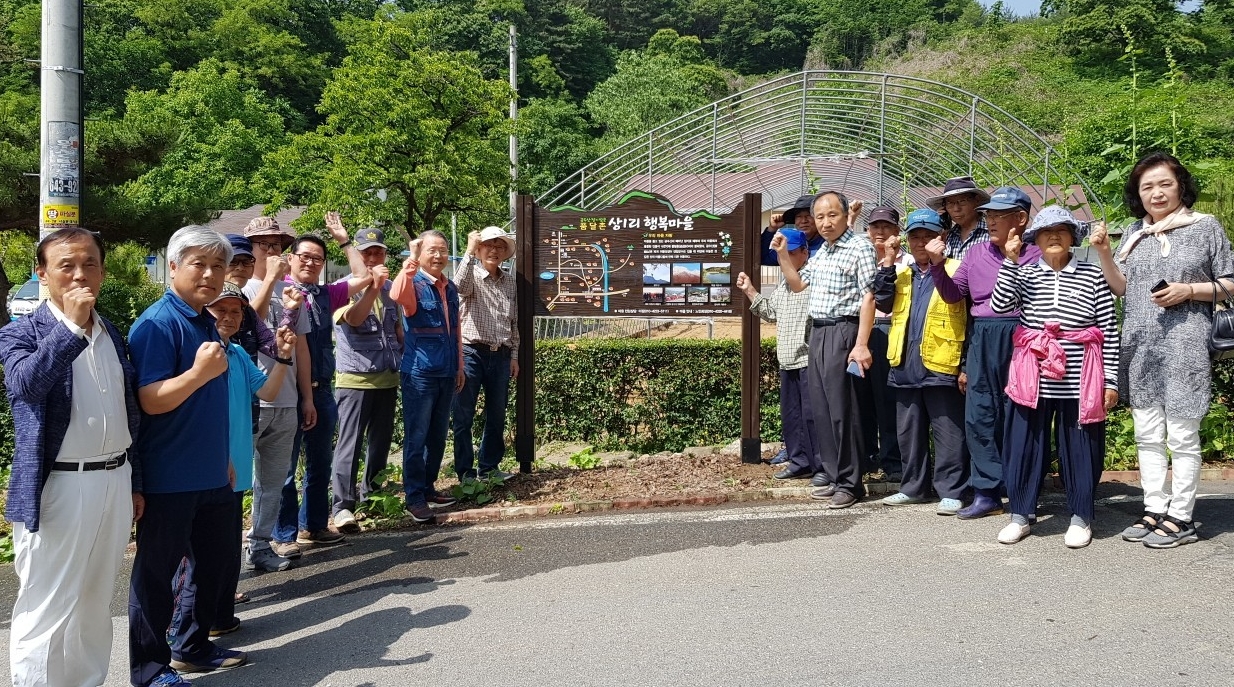 단양군 적성면 상1리 주민들이 지난 4일 동네 입구에 마을 알림판을 세운 뒤 기뻐하고 있다. 단양군 제공?