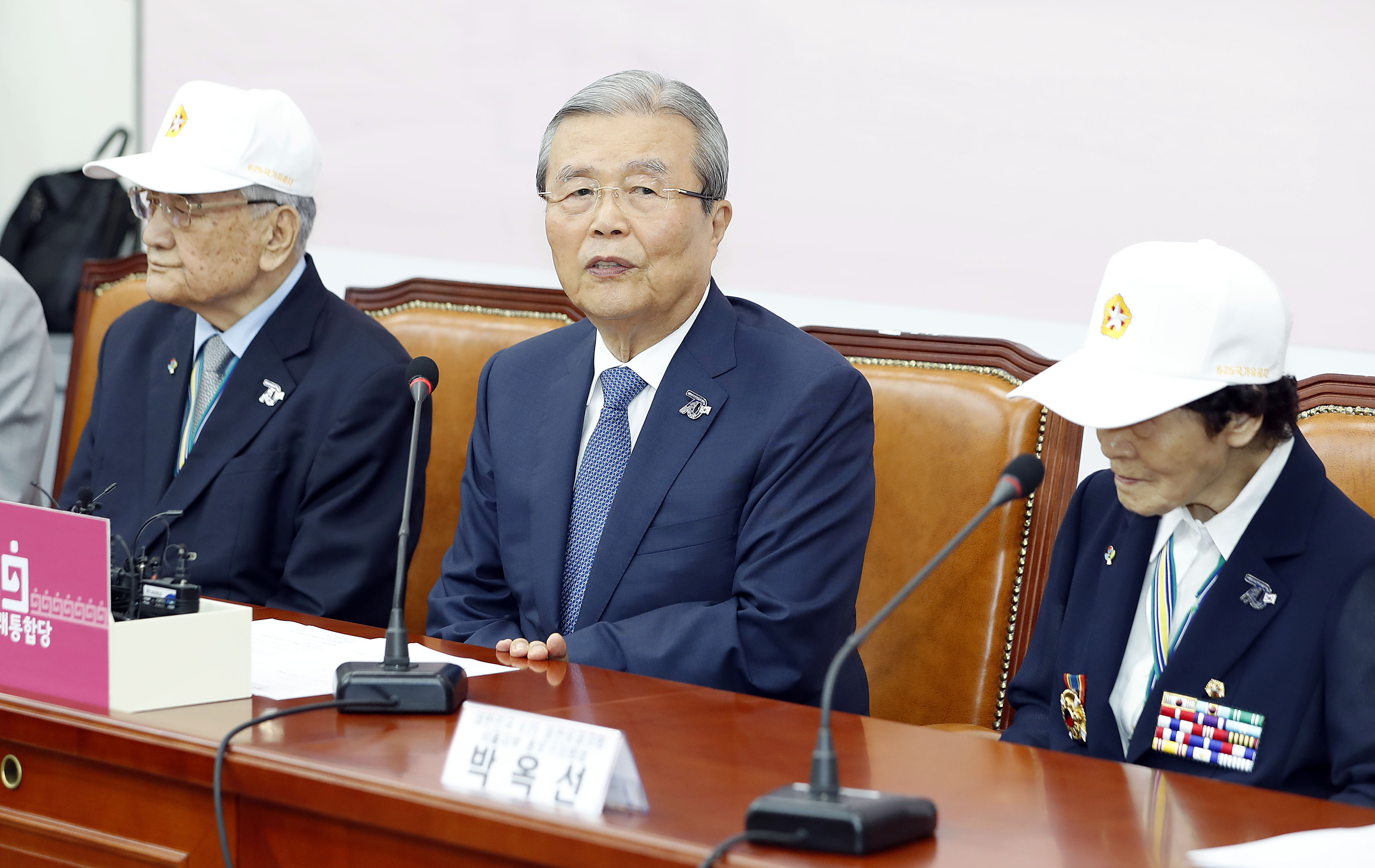 김종인(가운데) 미래통합당 비상대책위원장이 22일 국회에서 열린 비상대책위원회의에서 대한민국 6.25 참전유공자회 류연갑(왼쪽), 박옥선 유공자를 초청해 6.25 70주년 기념뱃지를 달아준 뒤 발언하고 있다. 뉴시스?