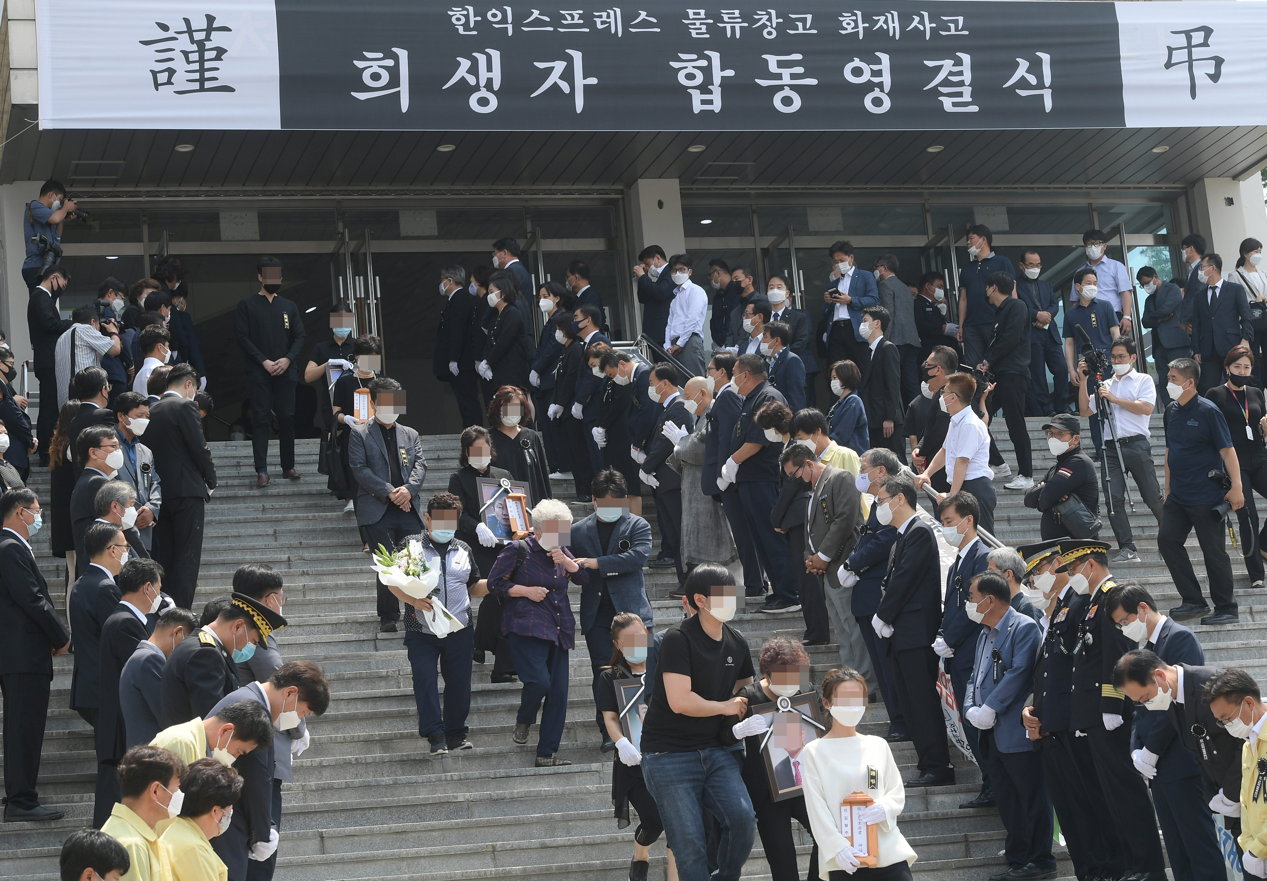 지난 20일 오전 경기 이천 서희 청소년문화센터에서 열린 '이천 한익스프레스 물류창고 화재 사고 희생자 합동 영결식'에서 유가족들이 위패와 영정사진을 들고 영결식장을 나서고 있다. 이천=뉴시스