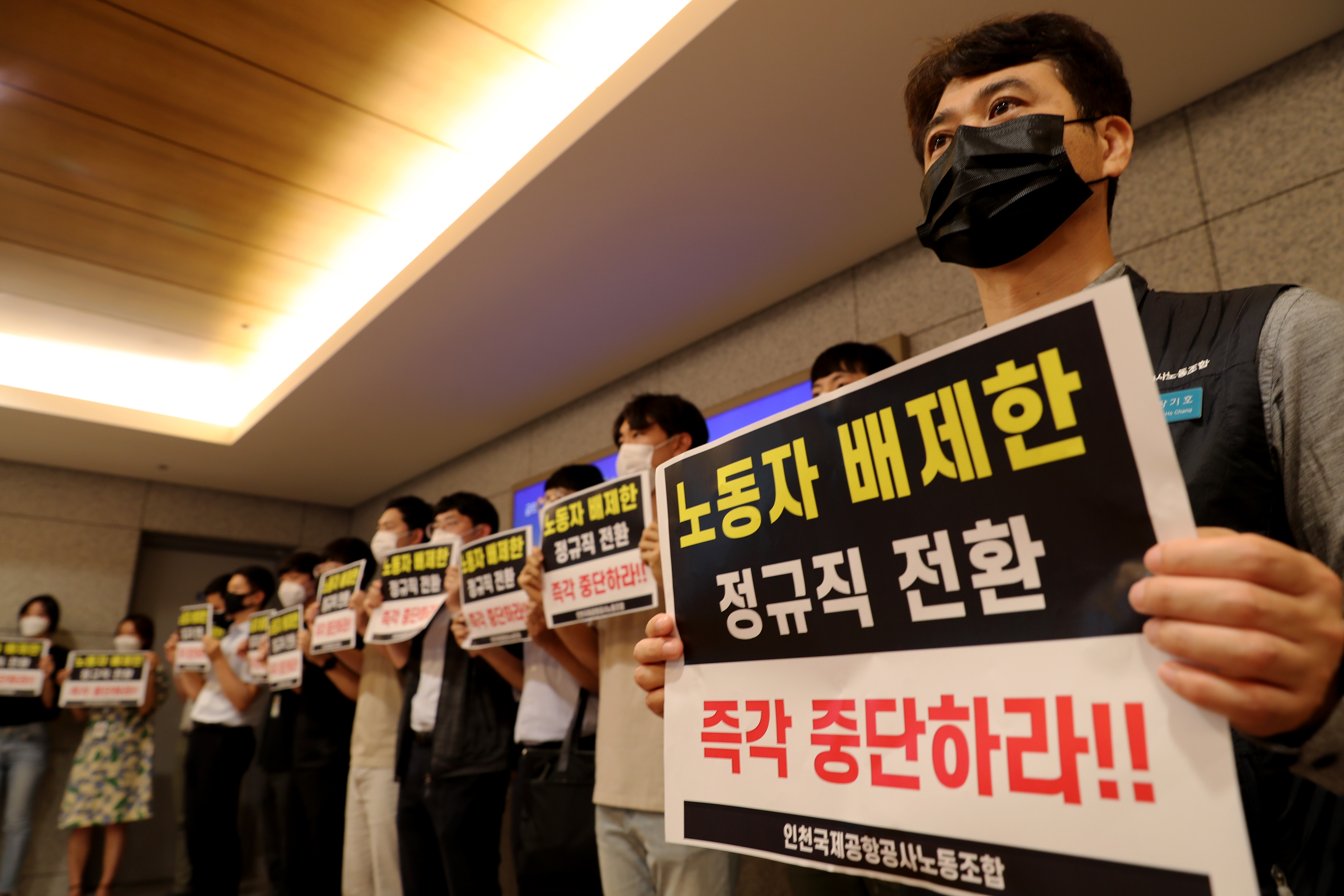 구본환 인천국제공항공사 사장이 22일 오후 인천공항1터미널에서 기자회견을 예고한 가운데 정규직 전환에 반대하는 노동자들이 피켓을 들고 항의하고 있다. 인천공항공사는 22일 인천공항 보안요원 1,900여명을 정규직화 한다고 밝혔다. 뉴스1