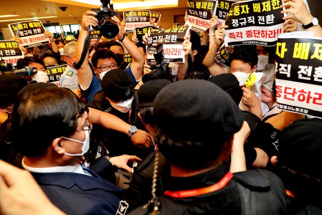 구본환 인천국제공항공사 사장이 22일 오후 인천공항1터미널에서 열린 기자회견에서 정규직 전환에 대한 입장을 밝히고 퇴장하자 노동자를 배제한 정규직 전환은 즉각 중단하라는 내용의 피켓을 든 노동조합원들이 항의를 하고 있다. 뉴스1