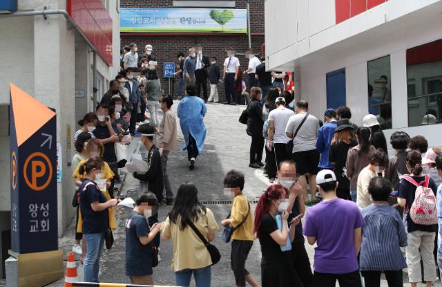 ?26일 신종 코로나바이러스 감염증 확진자가 무더기로 발생한 서울 관악구 왕성교회 앞 임시 선별진료소에서 교인들이 검체 채취를 받기 위해 길게 줄지어 서 있다. 연합뉴스