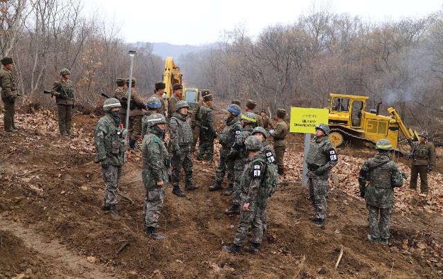 2018년 11월 22일 남북군사당국이 '판문점선언 이행을 위한 군사분야 합의서'에 따라 공동유해발굴의 원활한 추진을 위해 강원도 철원 ‘화살머리고지’ 일대에서 남북 군인들이 중부전선 군사분계선 인근에서 만나 도로연결작업을 하고 있다. 국방부 제공