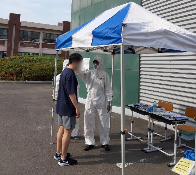 ?27일 오전 울산공업고등학교에서 열린 남해지방해양경찰청 해양경찰 채용 필기시험에서 한 응시자가 발열체크를 하고 있다. 남해해경청 제공