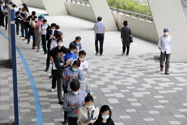 지난 17일 오전 경기 용인시민체육공원에서 열린 용인시 일자리 박람회를 찾은 구직자들이 코로나19 예방을 위해 거리를 둔 채 입장을 기다리고 있다. 뉴스1