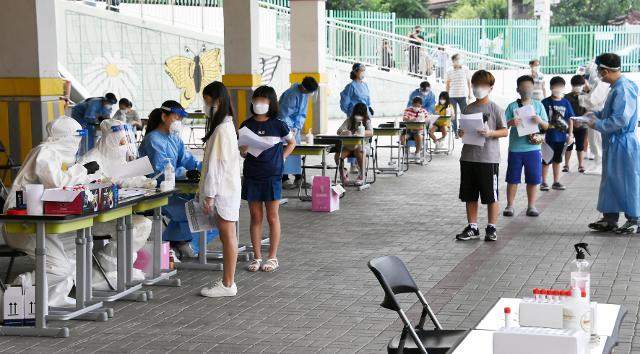 왕성교회 신종 코로나바이러스 감염증(코로나19) 집단감염 관련 확진자 중 한 명이 난우초등학교 시간강사로 밝혀진 가운데 28일 오전 서울 관악구 난우초등학교에 마련된 이동 선별진료소에서 학생들이 진료를 받기 위해 대기하고 있다. 뉴시스