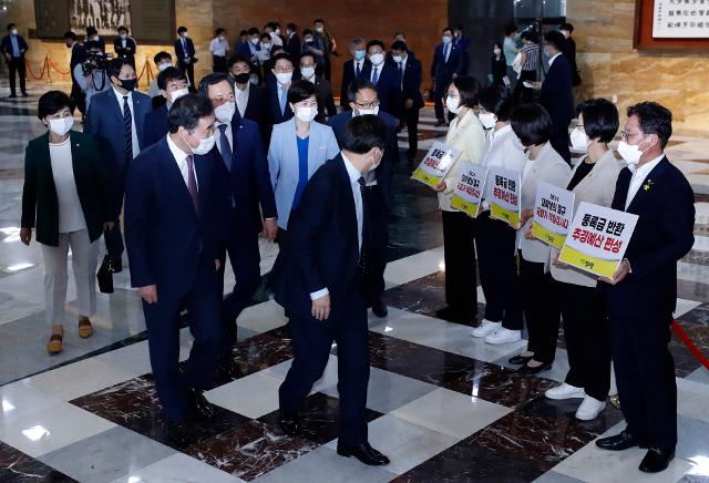 더불어민주당 이낙연 의원을 비롯한 의원들이 29일 서울 여의도 국회에서 열린 본회의에 입장하며 '등록금 반환 추경예산 편성'을 촉구하는 정의당 의원들을 바라보고 있다.? 뉴시스