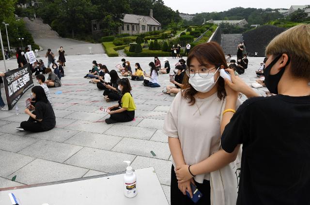 등록금 반환 및 선택적 패스제 도입을 요구하며 무기한 농성을 벌이던 이화여대 총학생회가 29일 오후 학교측과 대화하기 앞서 교내 파빌리온 앞에서 기자회견을 진행하기 앞서 참석자들의 체온을 재고 있다. 홍인기 기자