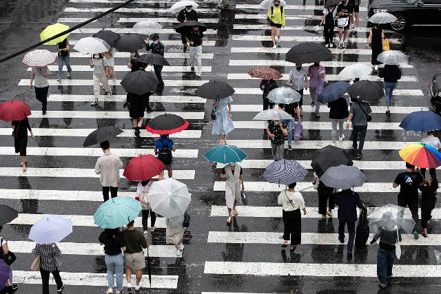 본격적인 여름 장마가 시작된 24일 오후 서울 광진구의 한 거리에서 시민들이 우산을 쓰고 발걸음을 옮기고 있다. 뉴스1