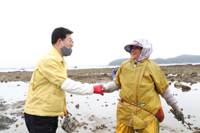 '도서 방문 대장정'에 나선 양승조(왼쪽)지사가 지난달 24일 장고도 갯벌에서 섬 주민과 ?함께 바지락을 캐며 이야기를 하고 있다. 충남도 제공