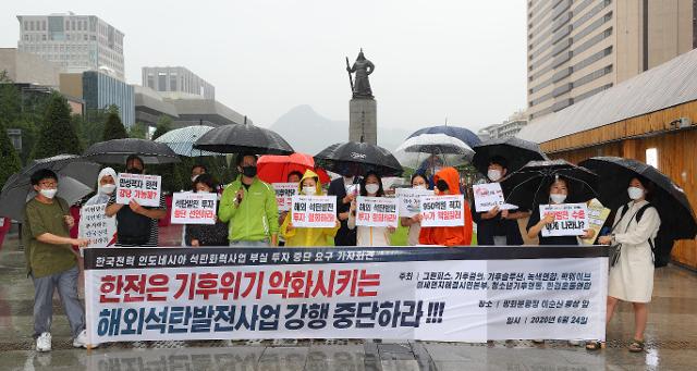 한전이 환경단체 등의 거센 반발에도 인도네시아 석탄화력발전소 투자 사업을 강행한 것을 두고 논란이 일고 있다. 사진은 그린피스, 기후결의 등 환경단체 관계자들이 6월 24일 서울 광화문광장에서 한전의 해외 석탄발전사업 투자 중단 촉구 기자회견을 하는 모습. 연합뉴스 고 있다. ?