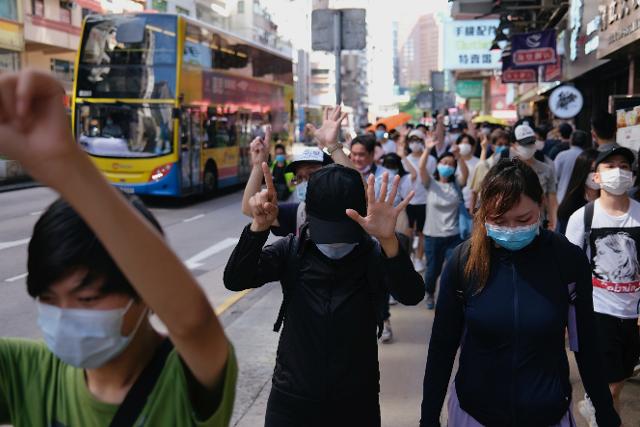 홍콩 시민들이 28일 보안법 통과를 앞두고 이에 항의하는 침묵의 행진을 벌이며 정부측에 대한 '5대 요구 조건'을 가리키는 의미로 다섯 손가락을 세우고 있다. 홍콩=로이터 연합뉴스