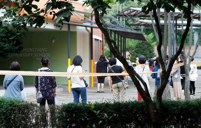 1일 오후 서울 동작구 문창초등학교에서 학교 교직원 및 관계자들이 신종 코로나바이러스 감염증(코로나19) 검사를 위해 줄 서 있다. 이날 오전 이 학교 6학년생이 코로나 확진 판정을 받아 학교가 폐쇄됐다. 뉴스1