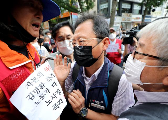 김명환 민주노총 위원장이 신종 코로나바이러스 감염증(코로나19) 위기 극복을 위한 노사정 대표자 협약식을 앞둔 1일 오전 서울 중구 민주노총 회의장에서 예정된 2020년 제11차 중앙집행위원회의 참석을 막는 조합원 등의 항의에 건물 앞에서 실랑이를 벌이고 있다. 뉴스1