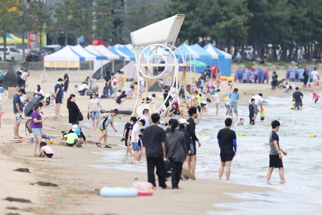 5일 경북 포항시 북구 영일대해수욕장에서 시민과 관광객들이 시원한 바다에 발을 담그며 더위를 식히고 있다. 포항=뉴스1