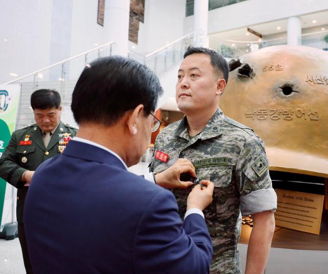 백선기 칠곡군수가 연평도 포격에 참전한 권준환 예비역 해병 소령에게 호국영웅 배지를 달아주고 있다. 칠곡군 제공