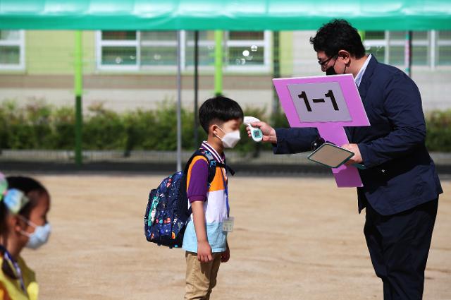 대구 동도초등학교에서 선생님이 1학년 신입생의 발열 여부를 체크하고 있다. 연합뉴스