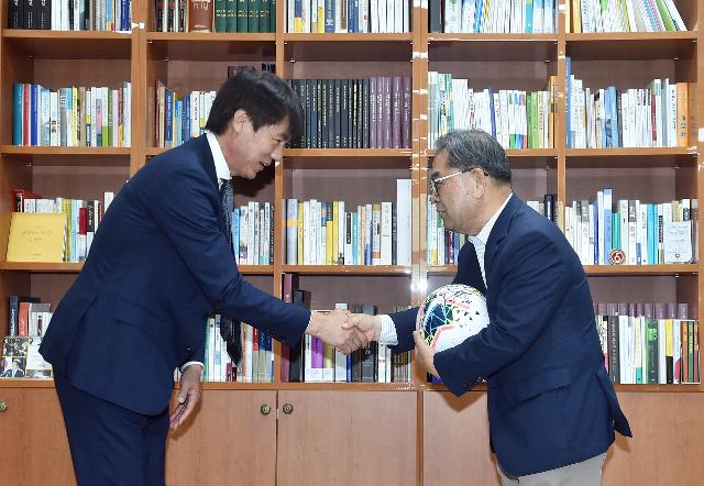 이재정(오른쪽) 경기교육감과 홍명보 대한축구협회 전무이사가 개방형 축구클럽 도입을 기념하며 악수하고 있다. 경기도교육청 제공