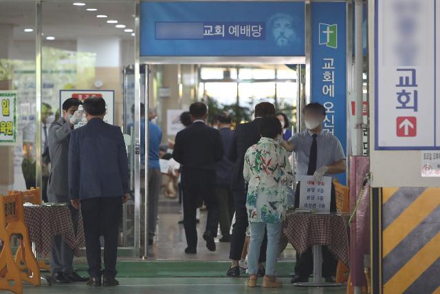 지난 5일 오전 광주 북구 한 교회에서 관계자가 예배에 참석하려는 신도의 체온을 확인하고 있다. 연합뉴스