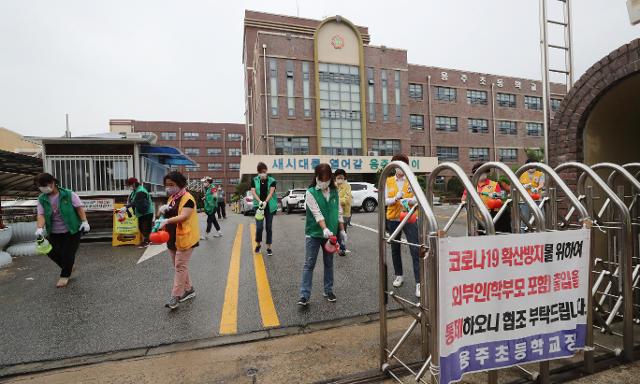 6일 오전 광주 북구의 한 초등학교에서 동행정복지센터 직원들과 봉사단체 회원들이 방역 작업을 하고 있다. 광주=연합뉴스