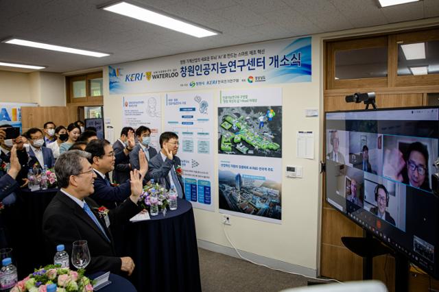 15일 한국전기연구원(KERI)창원본원에서 열린 'KERI-워털루대 창원인공지능연구센터'개소식에서 최규하(왼쪽 첫 번째)KERI원장과 허성무(왼쪽 두 번째)창원시장 등 참석자들이 캐나다 워털루대 교수진과 화상연결을 통해 인사하고 있다. KERI제공