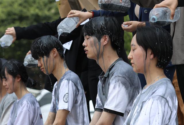 청년기후긴급행동 활동가들이 17일 오전 서울 광화문광장에서 열린 '기후위기 극복을 위한 진정한 그린뉴딜 촉구 기자회견'에서 정부를 규탄하며 청년들의 미래가 잿빛임을 상징하는 퍼포먼스를 하고 있다. 연합뉴스