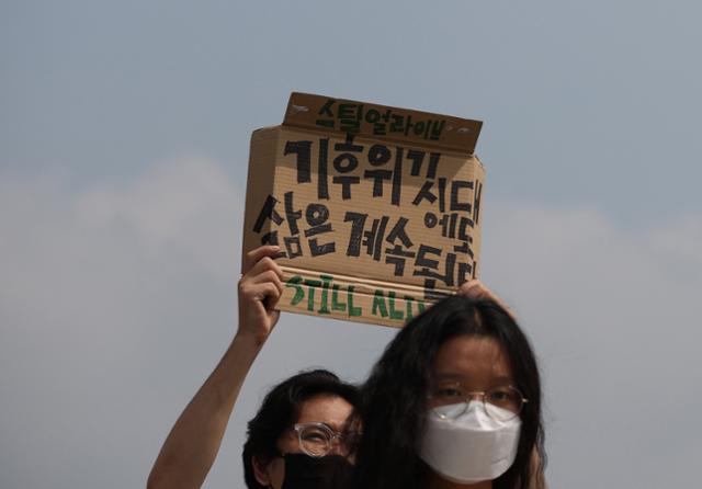 청년기후긴급행동 활동가들이 17일 오전 서울 광화문광장에서 기후위기 극복을 위한 진정한 그린뉴딜 촉구 기자회견을 열고 손팻말을 들고 있다. 이들은 그린뉴딜에 온실가스 절반 감축과 탄소중립을 명시할 것과 석탄발전소 종료 및 내연기관차 퇴출 계획을 포함할 것을 촉구했다. 연합뉴스