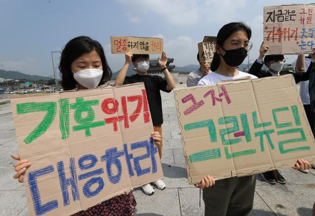 청년기후긴급행동 활동가들이 17일 오전 서울 광화문광장에서 기후위기 극복을 위한 진정한 그린뉴딜 촉구 기자회견을 열고 손팻말을 들고 있다. 이들은 그린뉴딜에 온실가스 절반 감축과 탄소중립을 명시할 것과 석탄발전소 종료 및 내연기관차 퇴출 계획을 포함할 것을 촉구했다. 연합뉴스