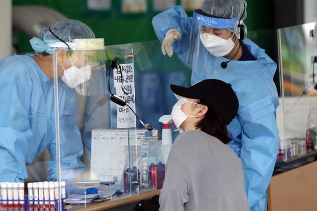 20일 오전 광주 서구보건소에 마련된 코로나19 선별진료소에서 의료진이 방문자에게 절차를 안내하고 있다. 연합뉴스.