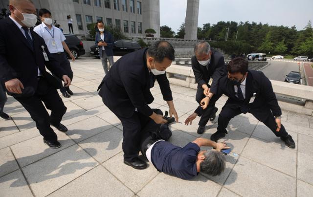 16일 오후 서울 여의도 국회에서 한 남성이 개원 연설을 마친 문재인 대통령을 향해 운동화를 집어던진 후 달려가다가 제지당하고 있다. 뉴스1