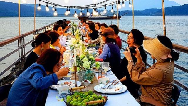 전남 광양시가 배알도 수변공원에서 진행한 여행 참여자들이 '매실 한 상'을 즐기고 있다.