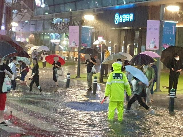 24일 부산 서면 삼정타워 앞 도로에 물이 차 올라 시민들이 불편을 겪고 있다. 부산경찰청 제공