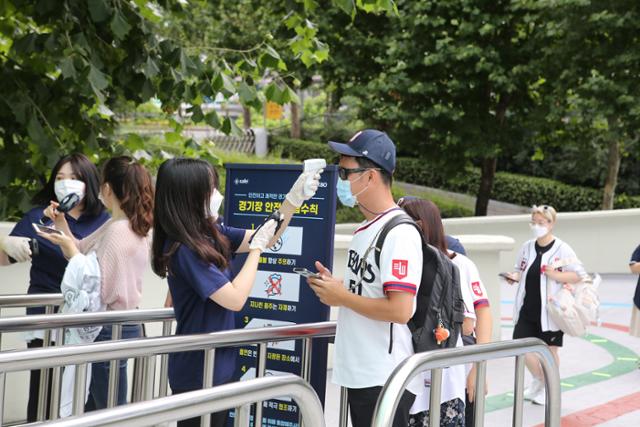 26일 서울 잠실야구장을 찾은 야구팬들이 발열 체크 후 입장하고 있다. 뉴스1