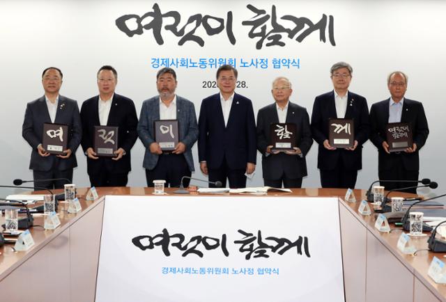 문재인 대통령과 노.사.정이 대통령 직속 사회적 대화기구인 경제사회노동위원회(경사노위)가 주재하는 코로나19 위기 극복을 위한 노.사.정 협약식에 처음으로 참석해 사회적 합의를 도출한 노.사.정 위원들과 '여럿이 함께'라고 적힌 동판을 들고 기념사진을 찍고 있다. 왼쪽부터 홍남기 경제부총리, 대한상공회의소 박용만 회장, 한국노총 김동명 위원장, 문 대통령, 한국경영자총협회 손경식 회장, 고용노동부 이재갑 장관, 경제사회노동위원회 문성현 위원장. 청와대 사진기자단