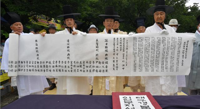 경북유림단체 대표들이 28일 군위군청 앞에서 통합신공항 후보지 결정을 촉구하는호소문을 낭독 후 들어 보이고 있다. 경북도 제공