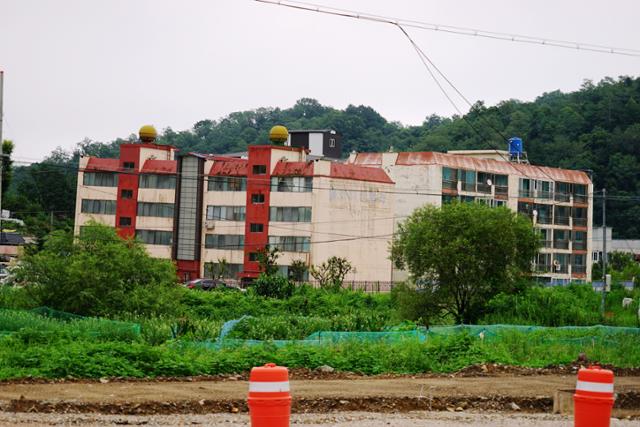 지난 1995년 준공 때부터 기울어진 경북 영덕군 강구면 D아파트. 아파트 주민들은 영덕군이 침수피해를 막기 위해 하천과 바다를 잇는 배수로를 건설하면서 인근 산에 터널을 뚫자 발파 진동으로 건물이 흔들린다며 항의 시위를 벌였다. 영덕=김정혜 기자 kjh@hankookilbo.com