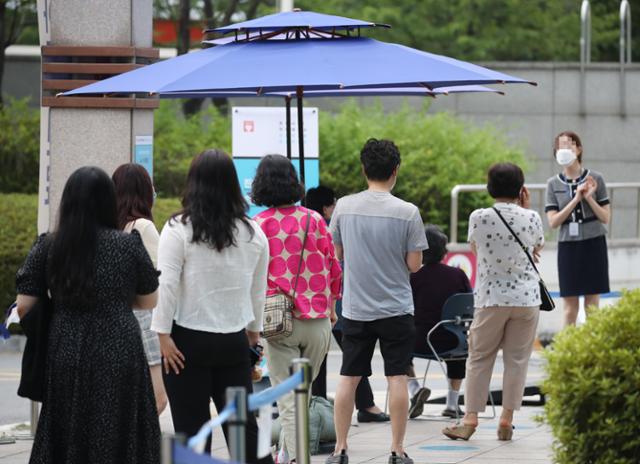 지난 21일 서울 중랑구 서울의료원 선별진료소 앞에서 시민들이 신종 코로나바이러스 감염증(코로나19) 검사를 받기 위해 길게 줄지어 서 있다. 연합뉴스