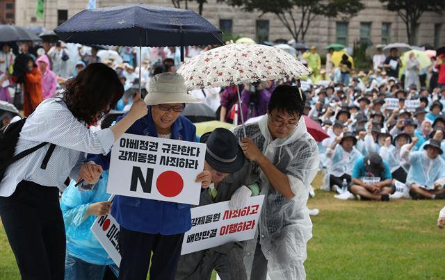 지난해 8월 15일 서울광장에서 열린 일제 강제동원 문제 해결을 위한 시민대회에서 강제징용 피해자 이춘식(오른쪽 두 번째) 할아버지와 양금덕 할머니가 무대에 오르고 있다.연합뉴스 자료사진