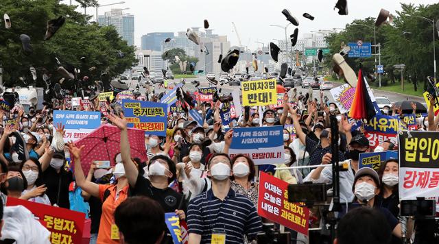 임대사업자협회 추진위원회, 임대차3법 반대모임 등의 회원들이 1일 오후 서울 영등포구 파크원 빌딩 앞에서 열린 정부의 고강도 부동산 규제 정책 반대하는 집회에서 정부를 규탄하며 신발투척 퍼포먼스를 하고 있다. 정부의 부동산 정책에 반발한 참석자들은 이날 임대차3법에 대해 과도한 사유재산 침해이며 위헌이라고 주장했다. 뉴스1