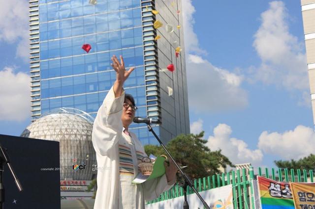 지난해 8월 인천에서 열린 퀴어문화축제에서 이동환 목사가 성소수자들에게 꽃잎을 뿌리며 축복기도를 하고 있다. 연합뉴스